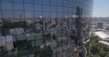 Hava. loseup cam gökdelen, iş binalar bölgesine, küresel ticaret. Pürüzsüz kamera hareketi ofis windows güneşli mavi gökyüzü beyaz bulutlar ile yansıtan binası önünde. 4k