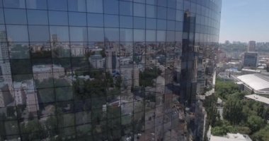 Hava. loseup cam gökdelen, iş binalar bölgesine, küresel ticaret. Pürüzsüz kamera hareketi ofis windows güneşli mavi gökyüzü beyaz bulutlar ile yansıtan binası önünde. 4k