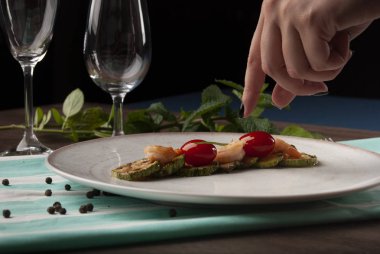 Karides, kabak ve beyaz tabakta kiraz domatesleri. 