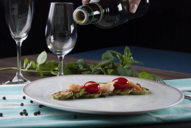 Karides, kabak ve beyaz tabakta kiraz domatesleri. 