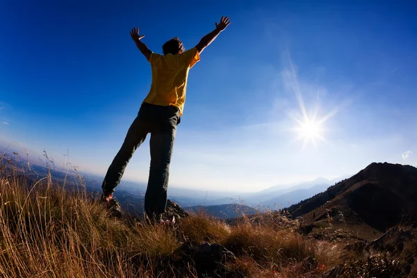 Hombre de pie eufórico en la cima de la montaña — Foto de Stock