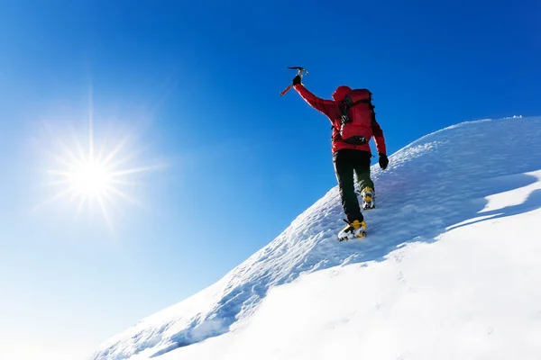 Extreme winter sports: climber at the top of a snowy peak in the — Stock Photo, Image