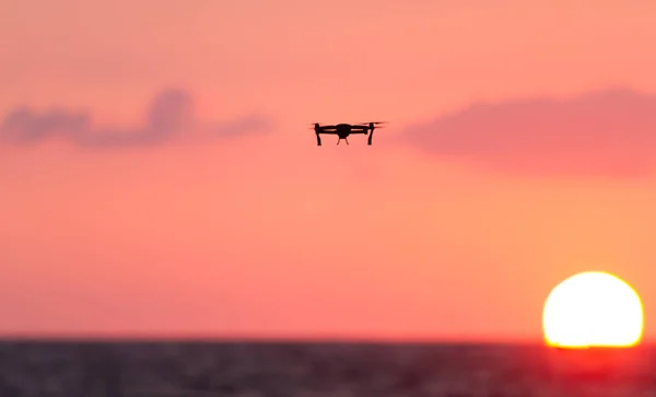 Drone flying over sea at sunset