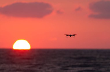 Gün batımında deniz üzerinde uçan uçak