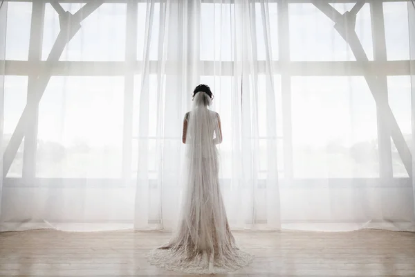 Nevěsta stojí v velké okno — Stock fotografie