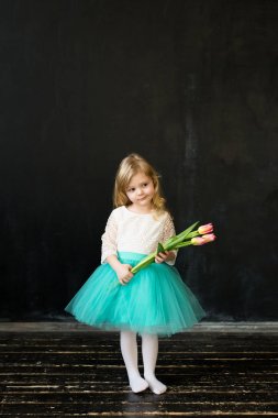 Beautiful girl with tulips on a black background