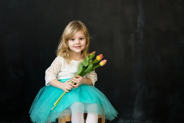 Красивая девушка с тюльпанами на черном фоне — стоковое фото