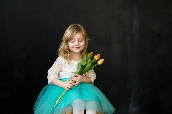 Piękna dziewczyna z tulipany na czarnym tle — Zdjęcie stockowe