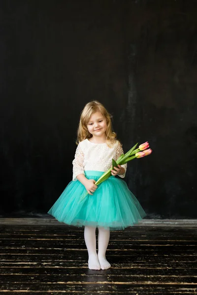 Krásná dívka s tulipány na černém pozadí — Stock fotografie