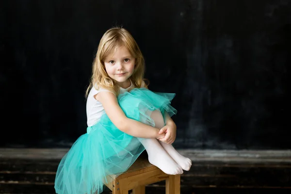 Lovely girl sitting on a chair. Black background. — Stock Photo, Image