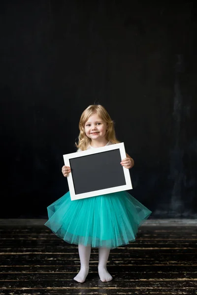 Cute little girl with a frame in her hands — Stock Photo, Image