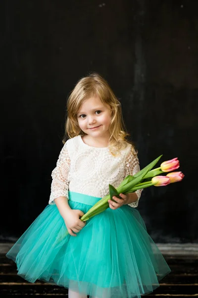 Красивая девушка с тюльпанами на черном фоне — стоковое фото