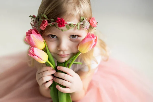 Krásná dívka s tulipány na světlém pozadí — Stock fotografie