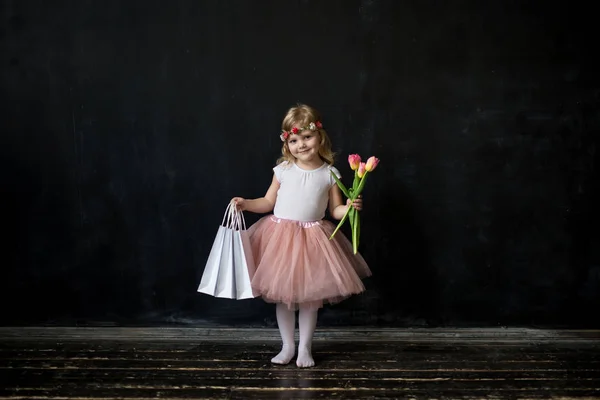Девушка с покупками и цветами — стоковое фото