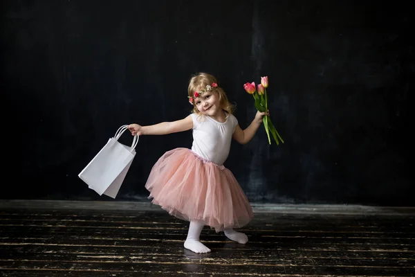 Menina com compras e flores — Fotografia de Stock