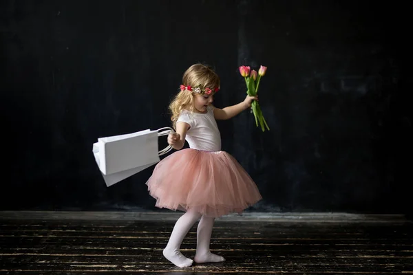 ショッピングと花を持つ少女 — ストック写真