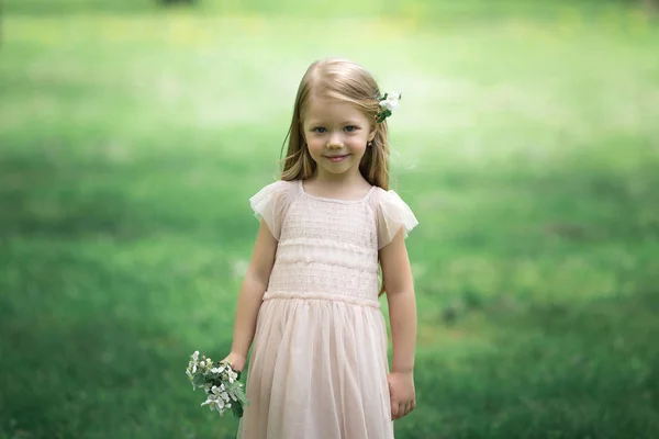 Маленькая девочка гуляет в яблоневом саду — стоковое фото