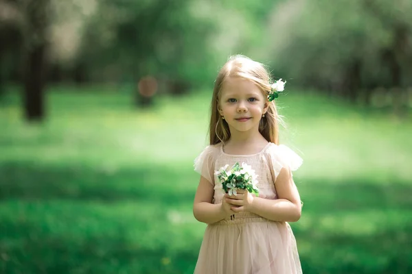 Kleines Mädchen spaziert in einem Apfelgarten — Stockfoto
