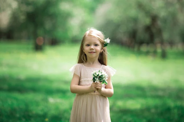 Kleines Mädchen spaziert in einem Apfelgarten — Stockfoto