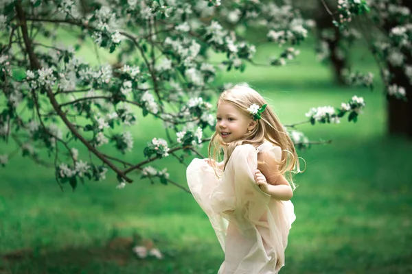 Küçük kız bir elma bahçesinde yürüyor — Stok fotoğraf