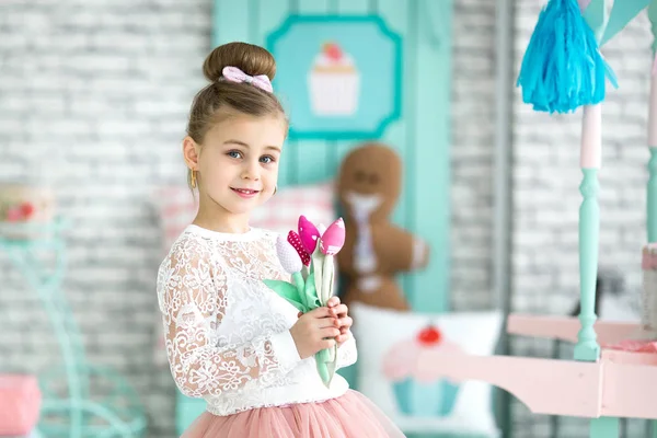 Pequena menina bonito segurando flores nas mãos — Fotografia de Stock