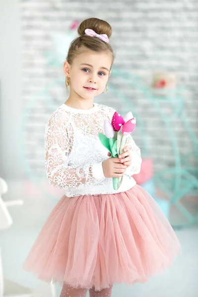 Pequena menina bonito segurando flores nas mãos — Fotografia de Stock