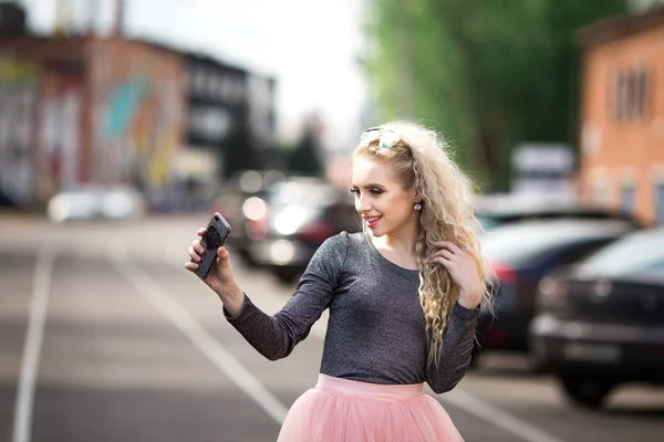 Junge lächelnde fröhliche blonde Mädchen macht Selfie im Stehen — Stockfoto