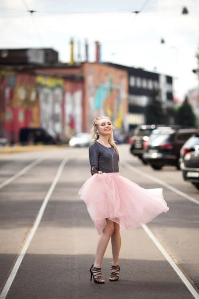 Bella ragazza ascolta la musica passeggiando lungo la strada — Foto Stock