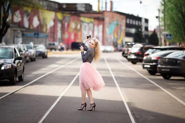 Junge lächelnde fröhliche blonde Mädchen macht Selfie im Stehen — Stockfoto