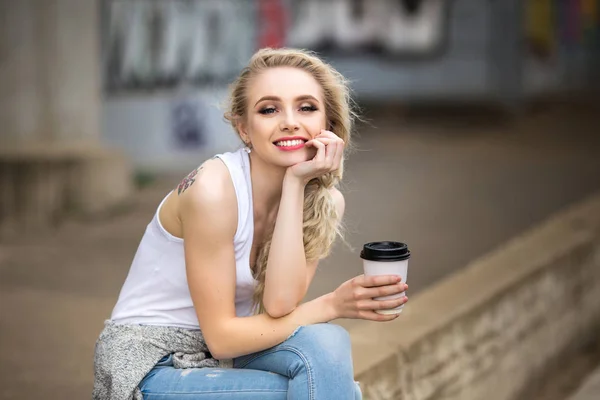 Gyönyörű lány iszik kávét az utcán — Stock Fotó