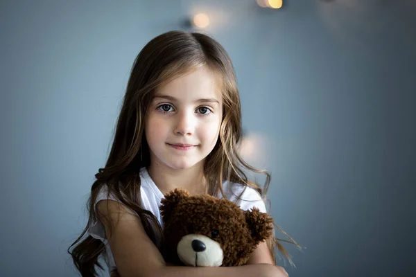 Retrato de una hermosa chica con un oso de juguete marrón — Foto de Stock