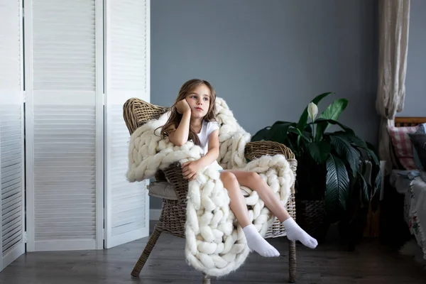 Sandalyede oturan küçük üzgün kız