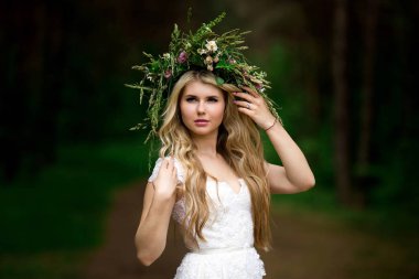 Beyaz bir elbise ve F çelenk içinde güzel bir gelin portresi