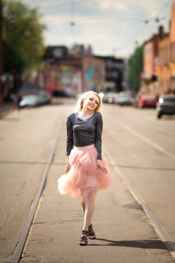 Güzel bir kız cadde boyunca yürüyor.