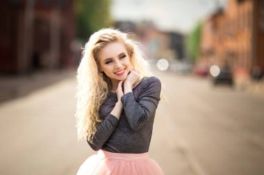 Güzel bir kız cadde boyunca yürüyor.