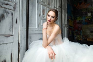 Güzel gelin parlak kalıcı makyaj ile yatakta oturur