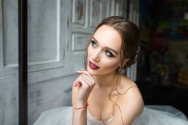 Güzel gelin parlak kalıcı makyaj ile yatakta oturur