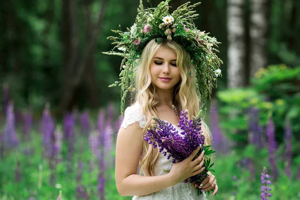 Menina bonita em vestido branco no campo de tremoço — Fotografia de Stock