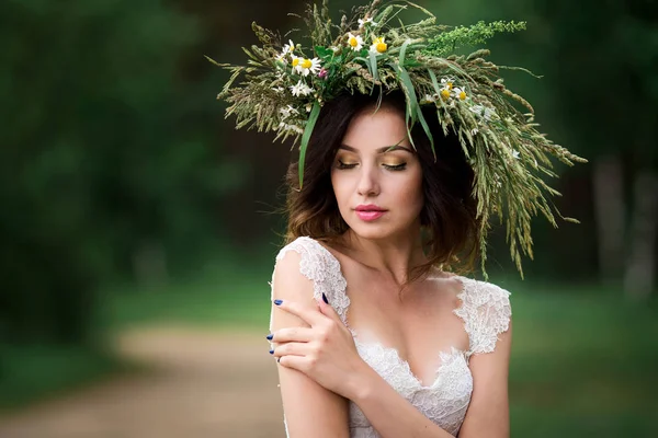 Beyaz bir elbise ve F çelenk içinde güzel bir gelin portresi