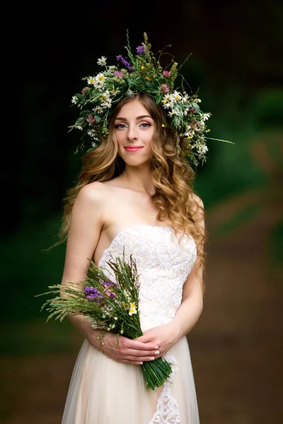 Bela noiva em um vestido branco com uma coroa de flores — Fotografia de Stock