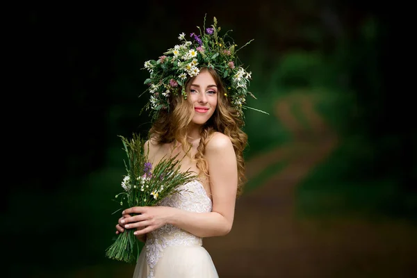 Bela noiva em um vestido branco com uma coroa de flores — Fotografia de Stock