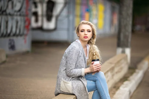 Красива сумна дівчина п'є каву на вулиці — стокове фото