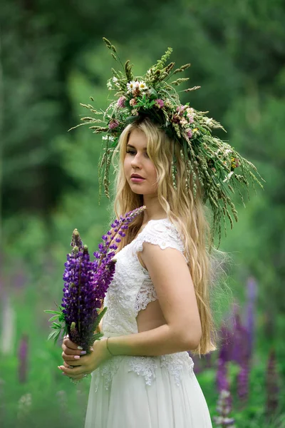 Menina bonita em vestido branco no campo de tremoço — Fotografia de Stock