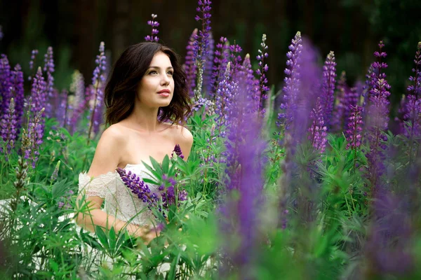 Menina bonita em vestido branco no campo de tremoço — Fotografia de Stock