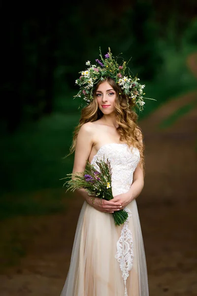 Bela noiva em um vestido branco com uma coroa de flores — Fotografia de Stock