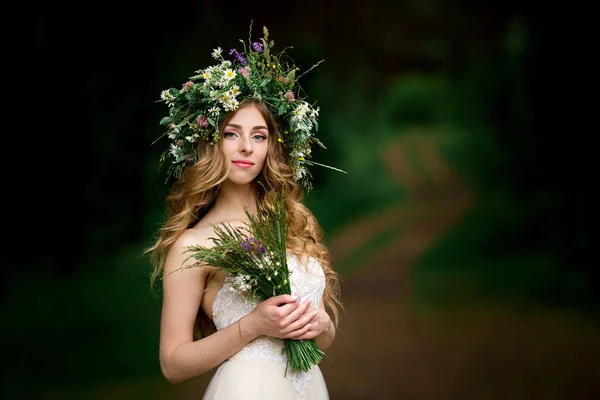 Bela noiva em um vestido branco com uma coroa de flores — Fotografia de Stock