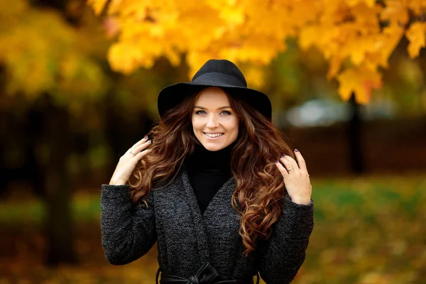 Fiatal nő az őszi hagyja a kezében, és csökken a sárga juhar gar — Stock Fotó