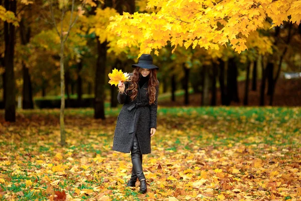 Mujer con hojas de otoño en la mano y caída de arce amarillo fondo del jardín —  Fotos de Stock