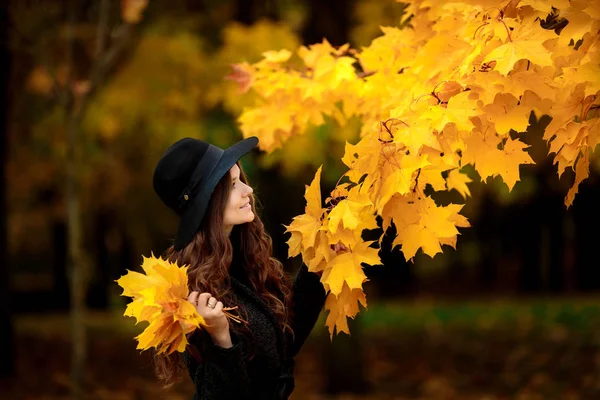 Donna con foglie autunnali in mano e acero giallo autunno giardino sfondo — Foto Stock