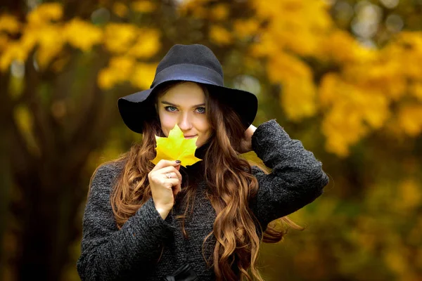 秋の女性手に葉し、黄色のもみじの庭の背景に落ちる — ストック写真